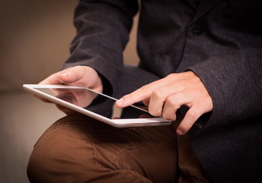 man scrolling on iPad