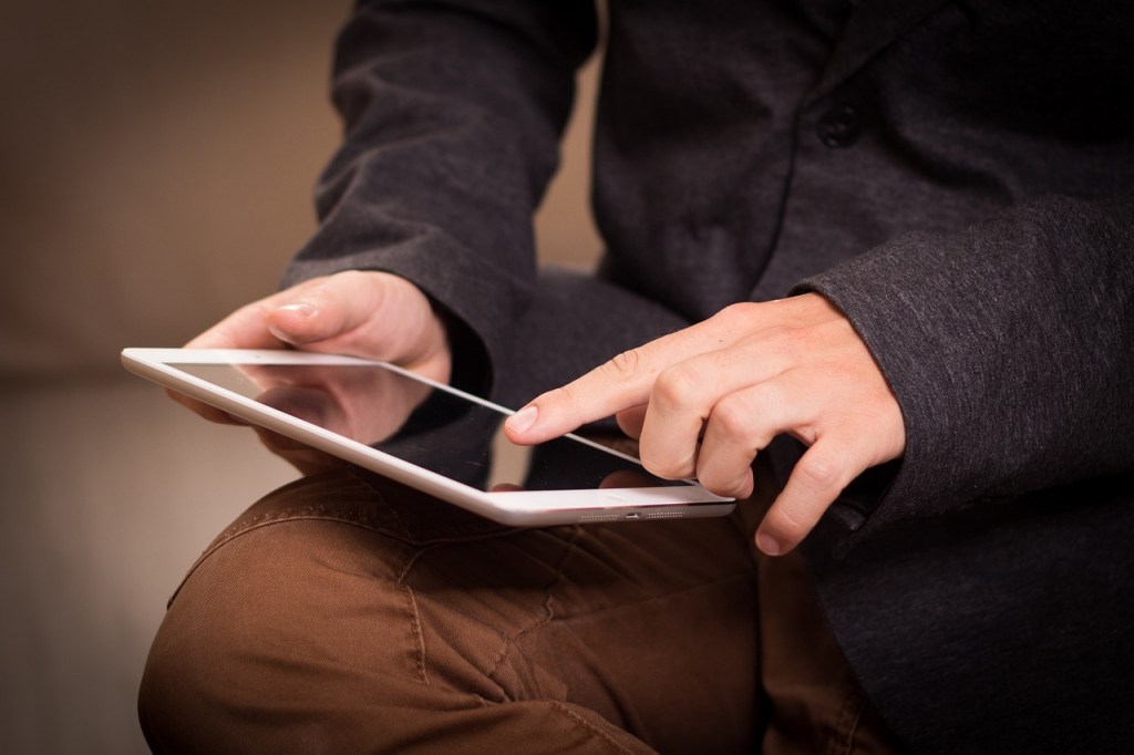 man scrolling on iPad